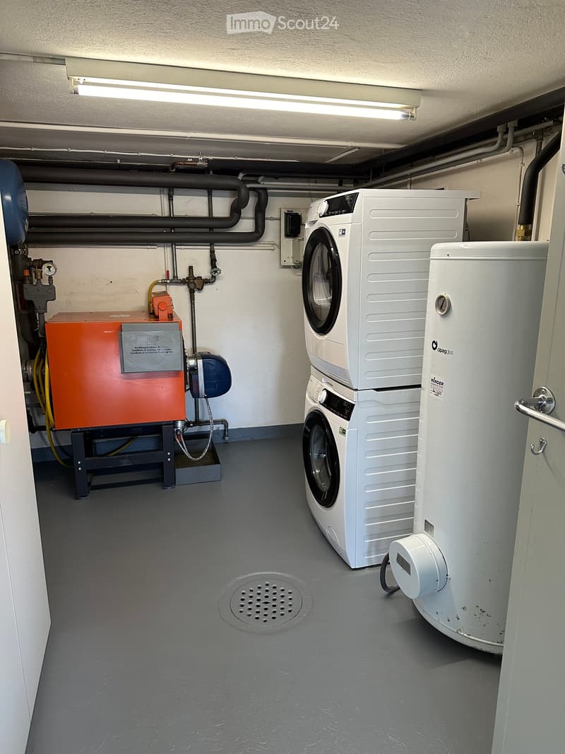 utility room with a laundry machine, water heater, and heating system