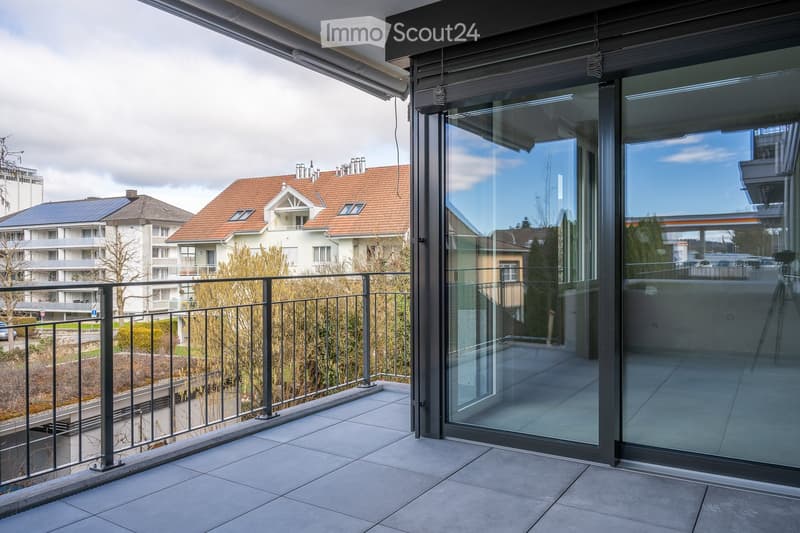 Balcony with glass railing, glass door, and tiled floor