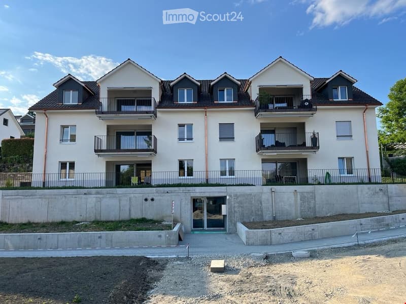4 story apartment building, multiple balconies, raised ground floor, garage