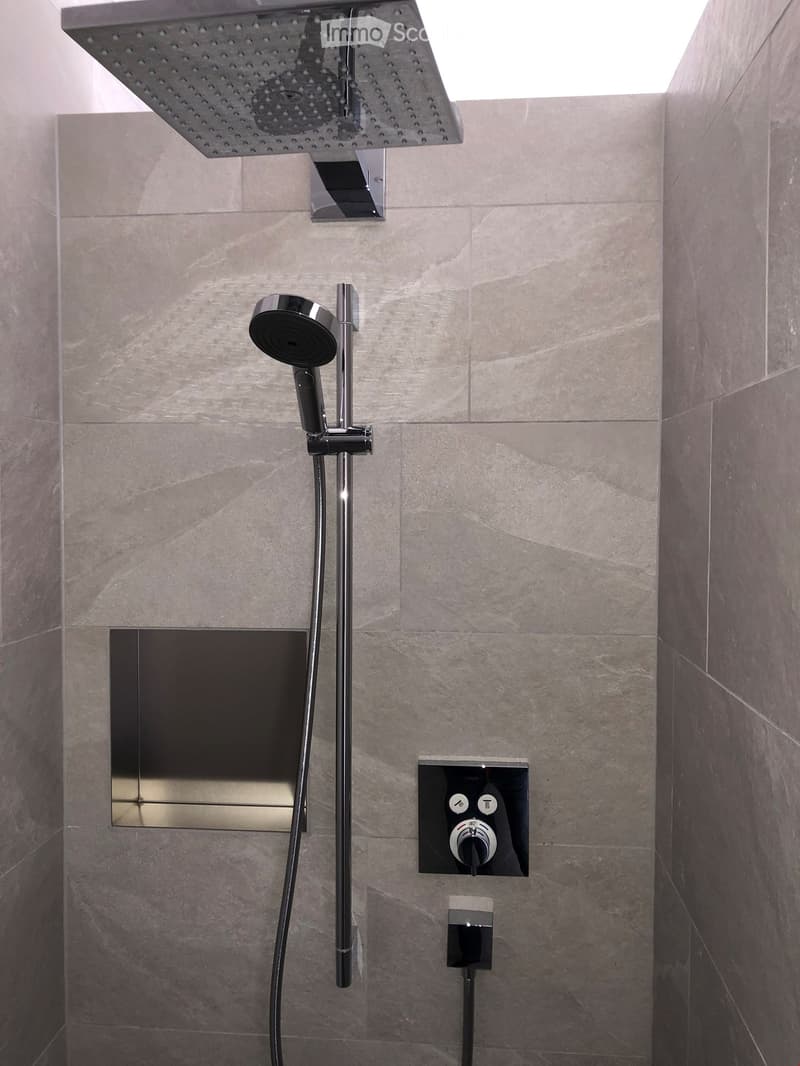 Modern shower with rain shower, wall mounted controls, silver and black finishes, square tiles