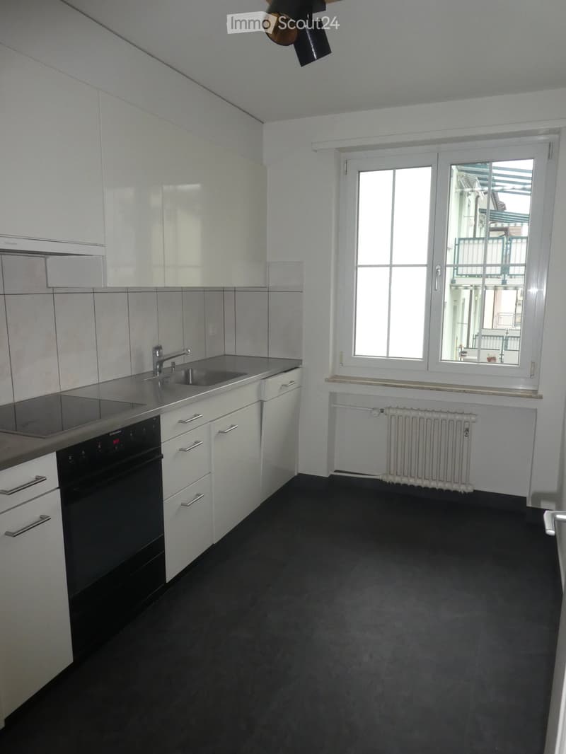 modern white kitchen, stainless steel sink, countertop, gas stove, oven, tiles, and window