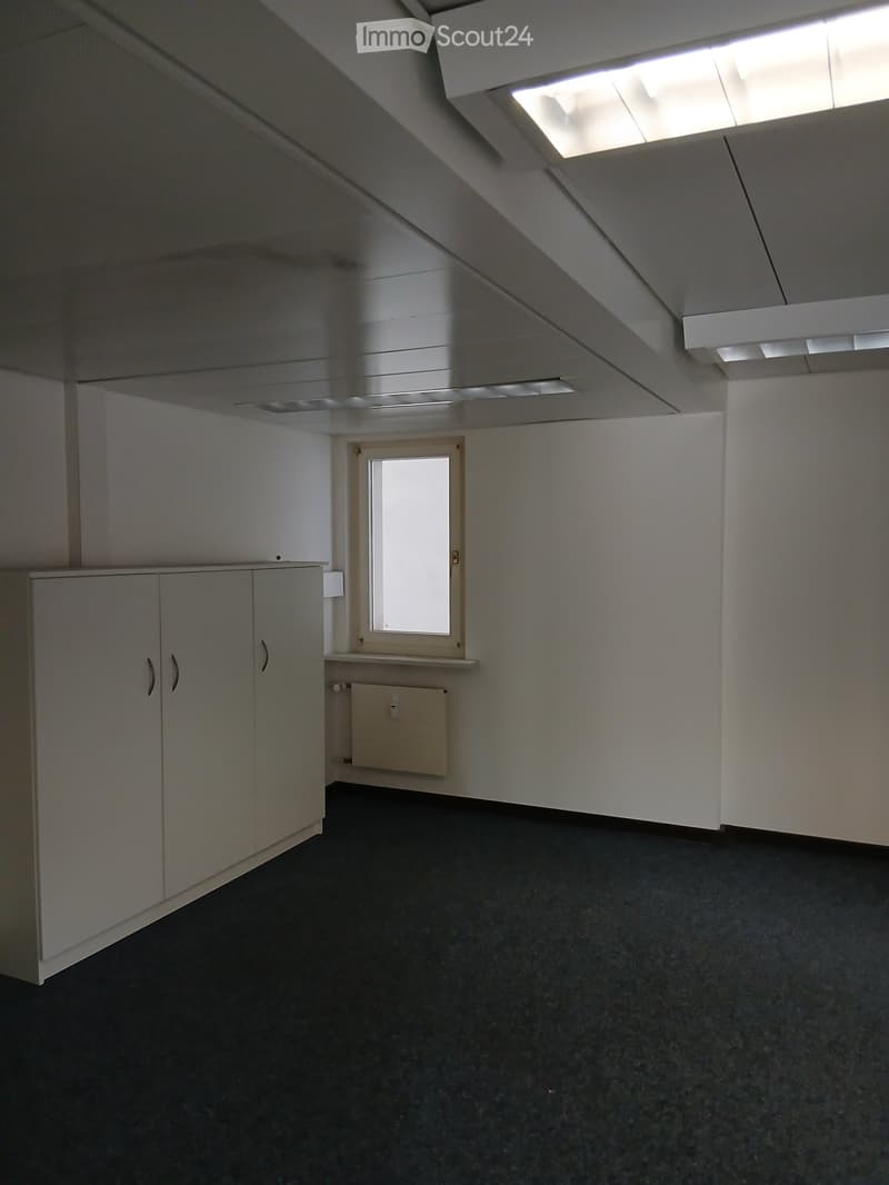 empty room, 3 white cabinets, black floor, white walls, window, radiator