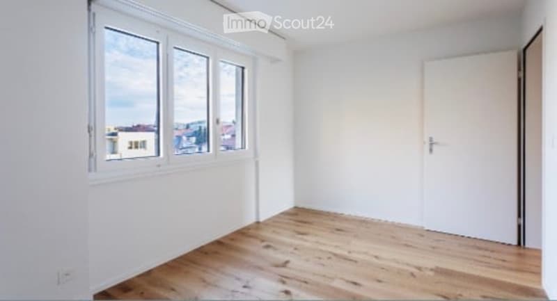 white walls, wooden floor, large window, open door