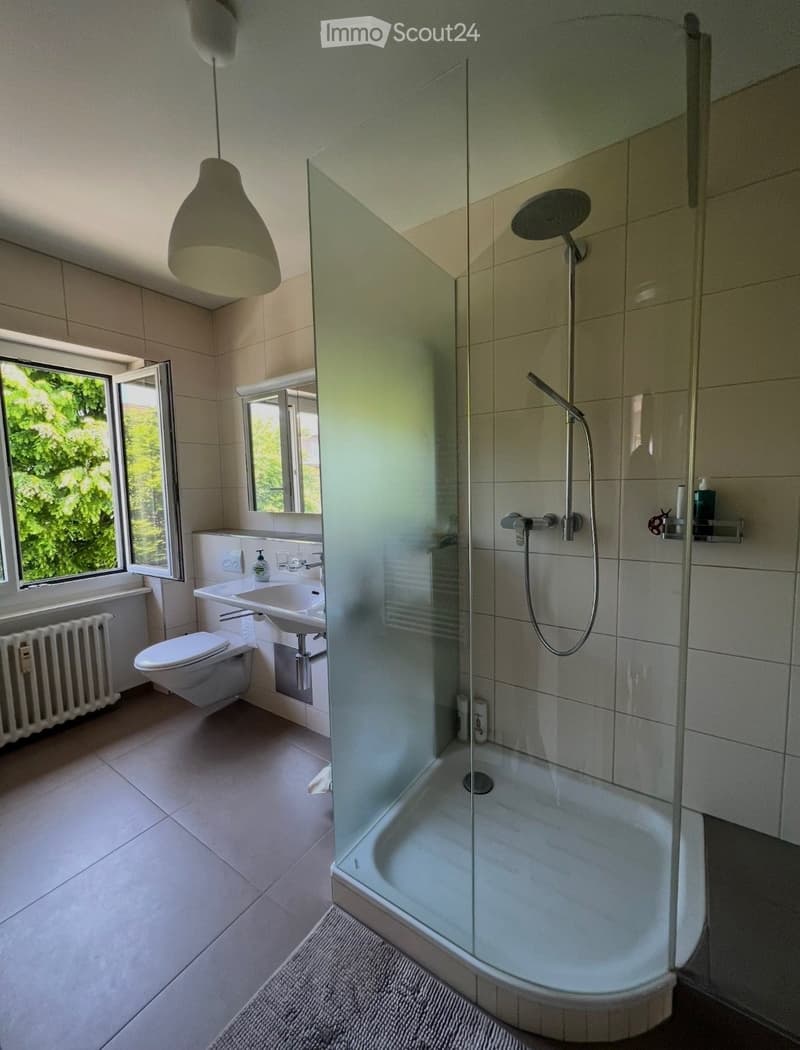 Tiled floor, toilet, sink, shower, radiator, window, shower curtain