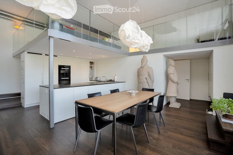 dining area with wooden table and black chairs, kitchen, glass railings