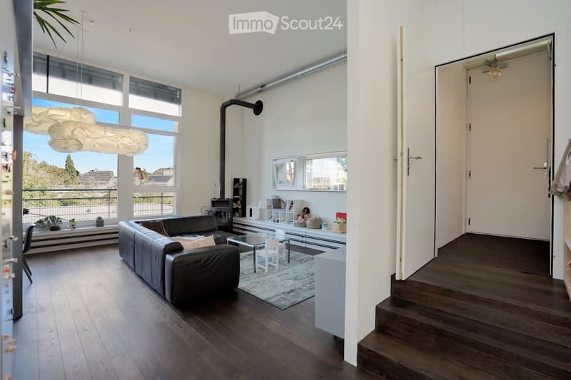 wooden floor, black leather couch, large windows, balcony with plants