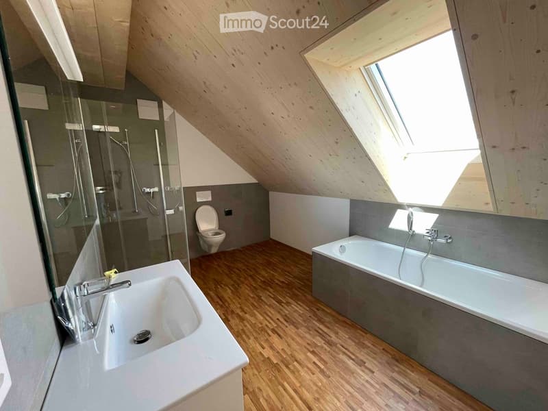 wooden floor, white bathtub, gray walls, glass shower enclosure, white sink