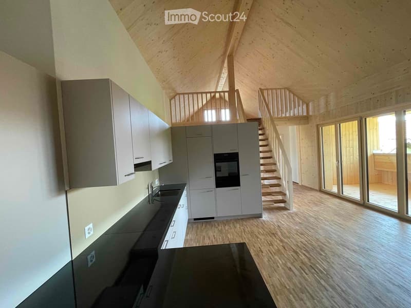 Wooden cabinets, tiled countertop, black kitchen sink, double door oven, staircase, balcony