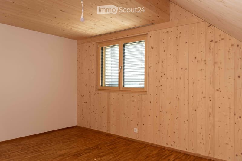 Room with wooden walls and ceiling, wooden floor, window, and a power outlet.