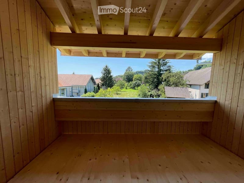 Empty room with wooden walls, wooden ceiling, wooden window sill and wooden flooring, a view of the outside landscape