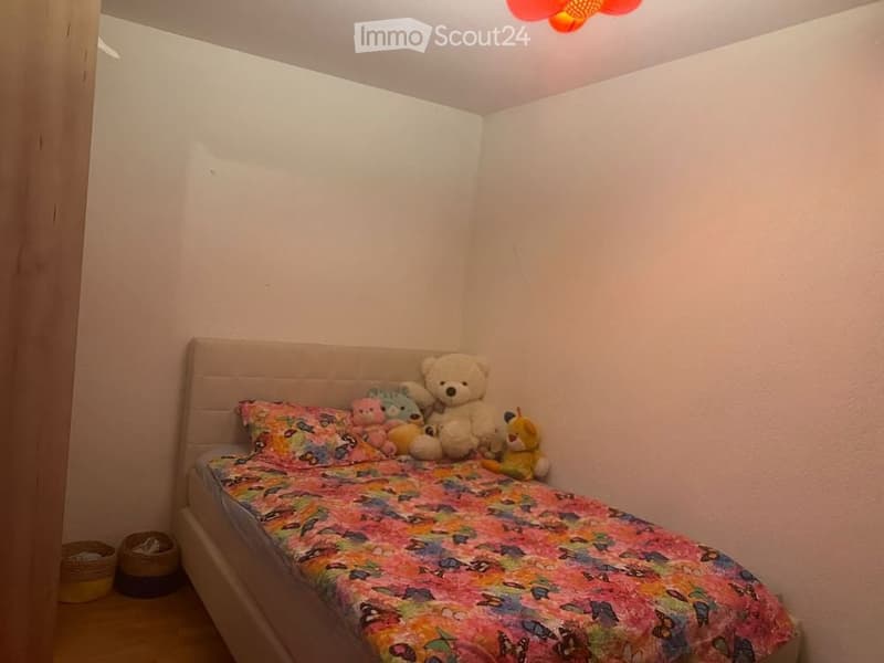 Single bed, flower print bedsheet, teddy bears and toys, hanging basket, lamp on ceiling