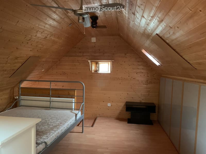 wooden walls, wooden floor, single bed, ceiling fan, wooden headboard, white radiator, wooden cabinet, electrical outlet