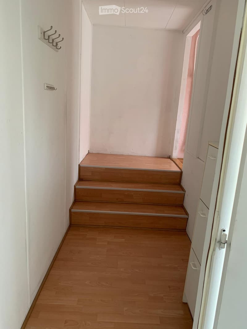 Staircase leading to upper floor, wooden steps, white walls, wooden flooring, empty hallway