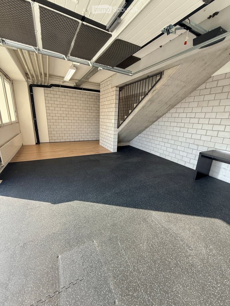 Empty room, tile floor, white wall, metal stair, window, ceiling pipes, mounted lamp