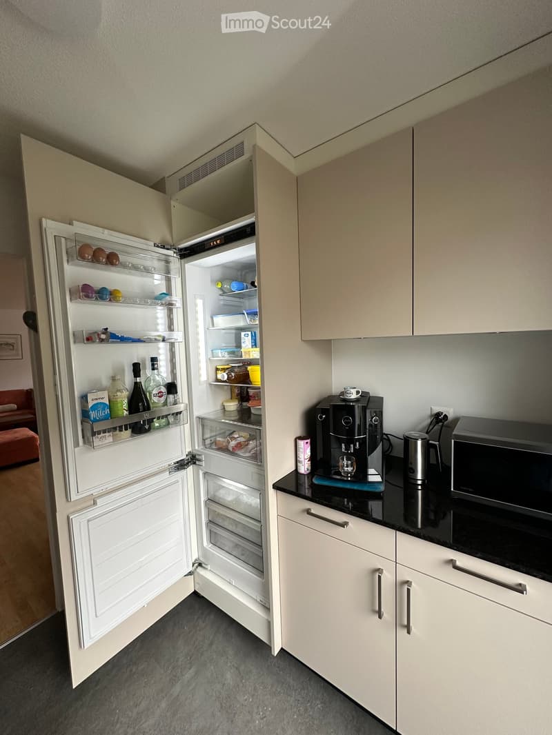 Modern kitchen with island, fridge, coffee machine, microwave, cabinets, countertop