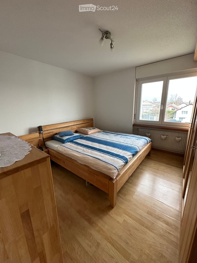 bedroom with bed, wooden furniture, large window