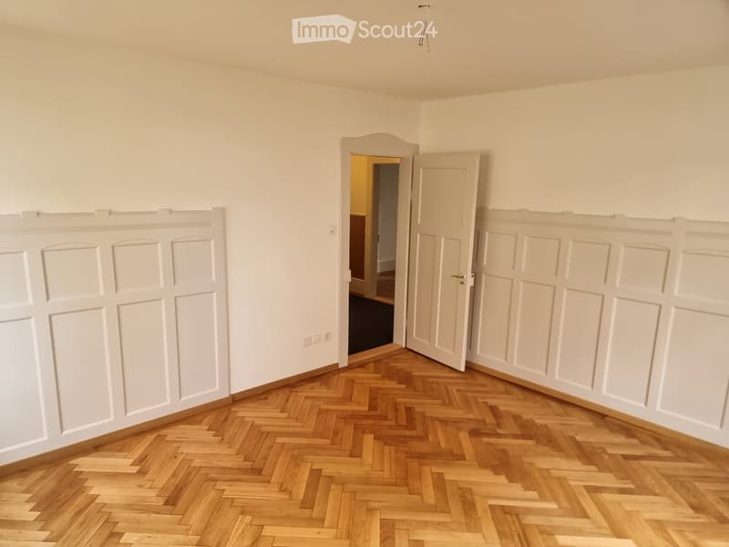 hardwood herringbone flooring, white walls, open door, power outlets, wood flooring