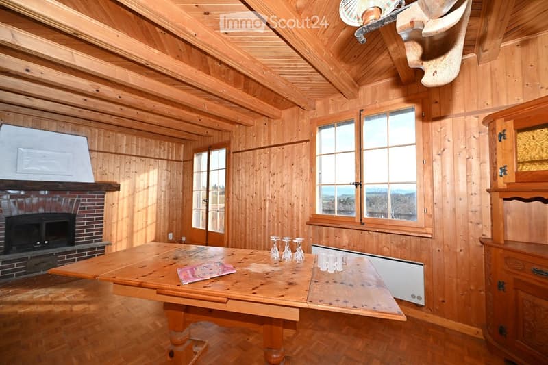 Fireplace, wooden interior, wooden table, panoramic windows, radiator, parquet floor
