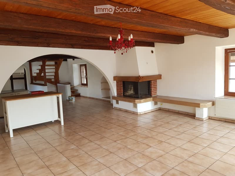 Open space, wooden beams, tiled floor, fireplace, staircase, desk
