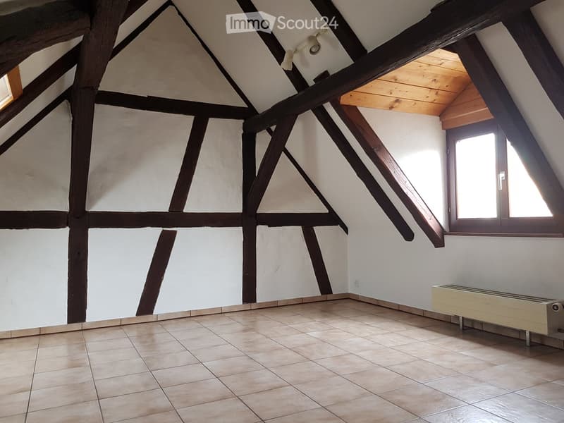 Tiled floor, exposed wooden beams, attic room, windows, heater