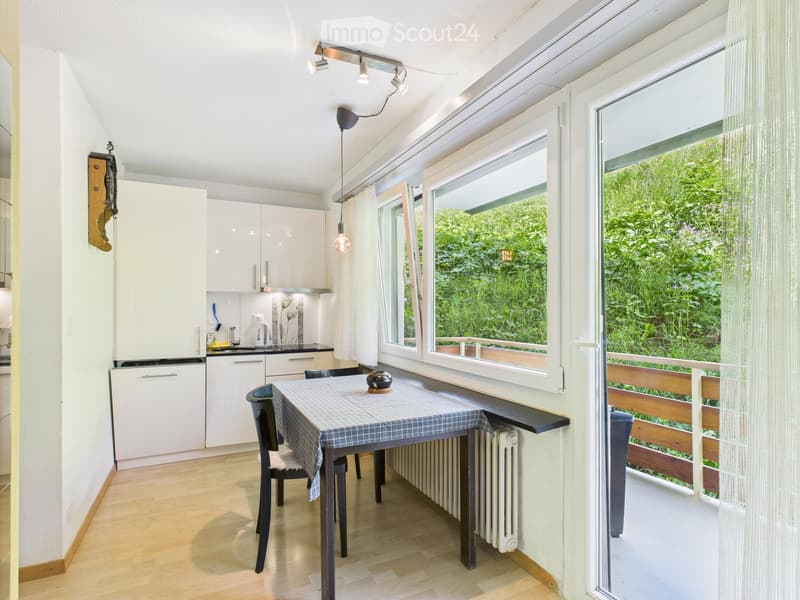 kitchen with dining table, radiator, 2 chairs, windows, balcony, wooden floor