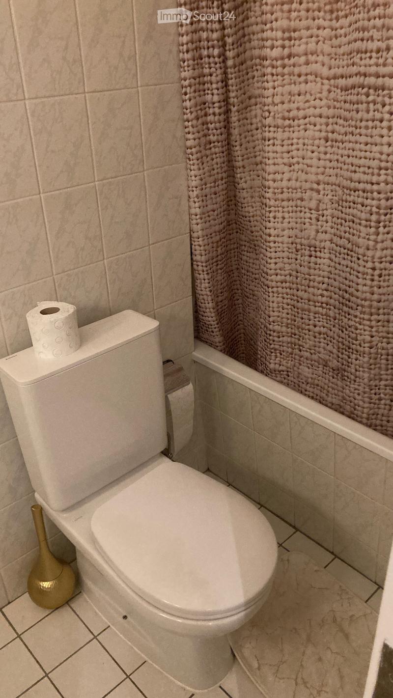 Bathroom with toilet, bathtub, and shower curtain