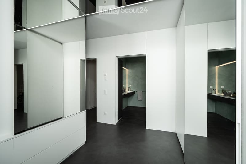 modern bathroom with white walls, black floor, large mirror, sink, towel rack, recessed lighting