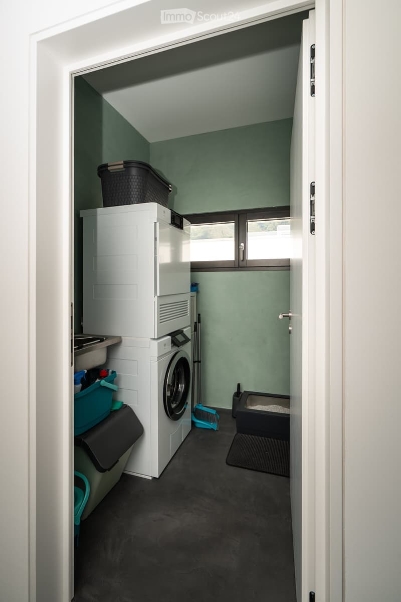 Laundry room with washing machine, dryer, sink, and storage baskets