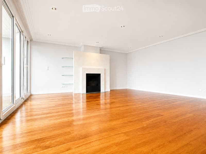Unfurnished Room. Empty room with polished hardwood flooring, white walls, recessed lighting, and a fireplace with built-in shelving.
