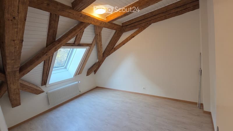 Beamed attic room, wooden beams, radiator, ceiling light, window, wooden flooring