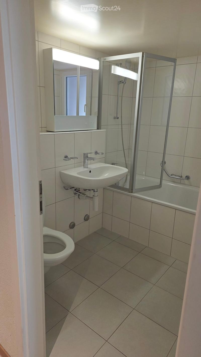 Modern bathroom, white tile, toilet, sink, shower, bathtub, glass wall, mirror