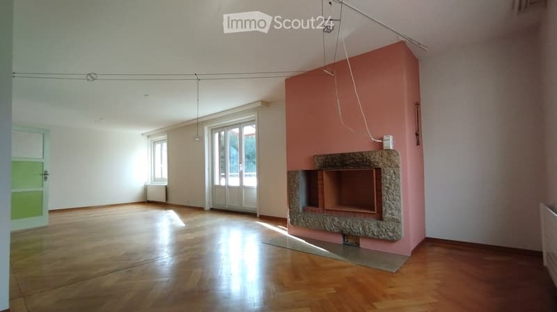 Empty room with wooden floors, pink feature wall, fireplace, windows