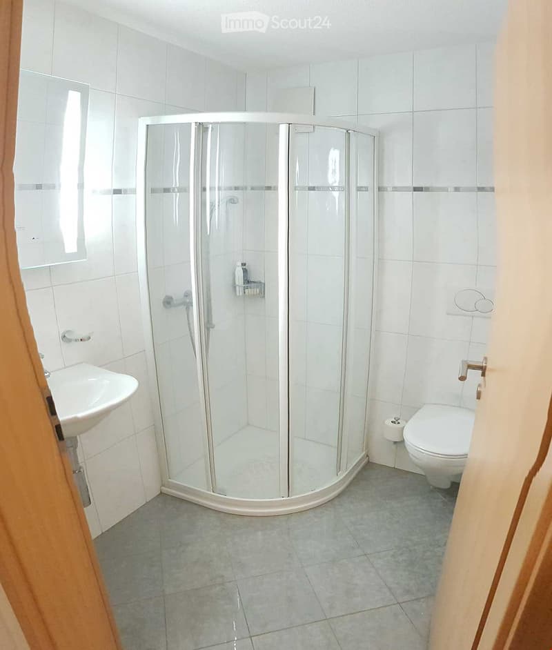 shower stall, toilet, sink, tile flooring, mirror, toilet paper holder