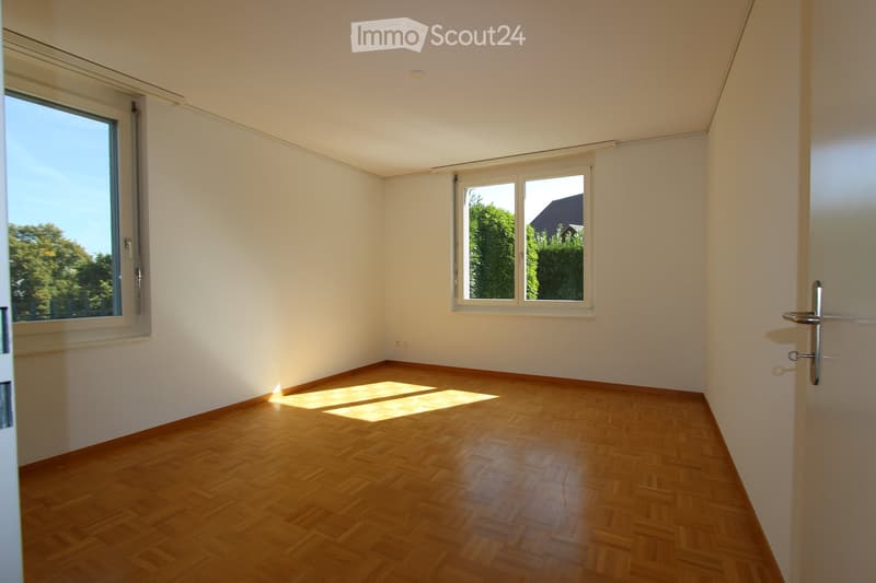 empty room, wooden floor, white walls, two windows, sunlight streaming in