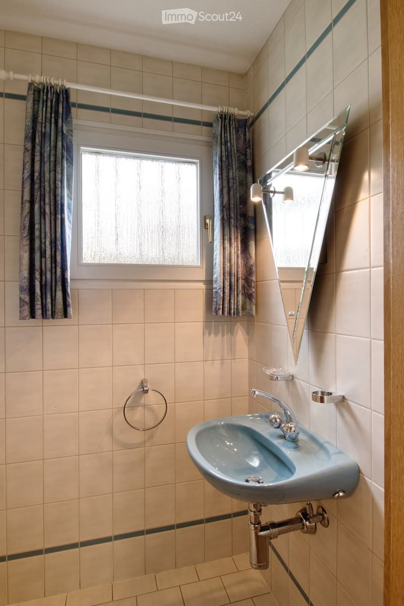 Bathroom with white tiles, blue sink, mirror, faucet, window with curtains, towel rack