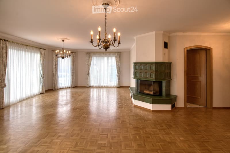 Fireplace with green cabinet, 2 chandeliers, parquet floor, white walls, long windows with white curtains