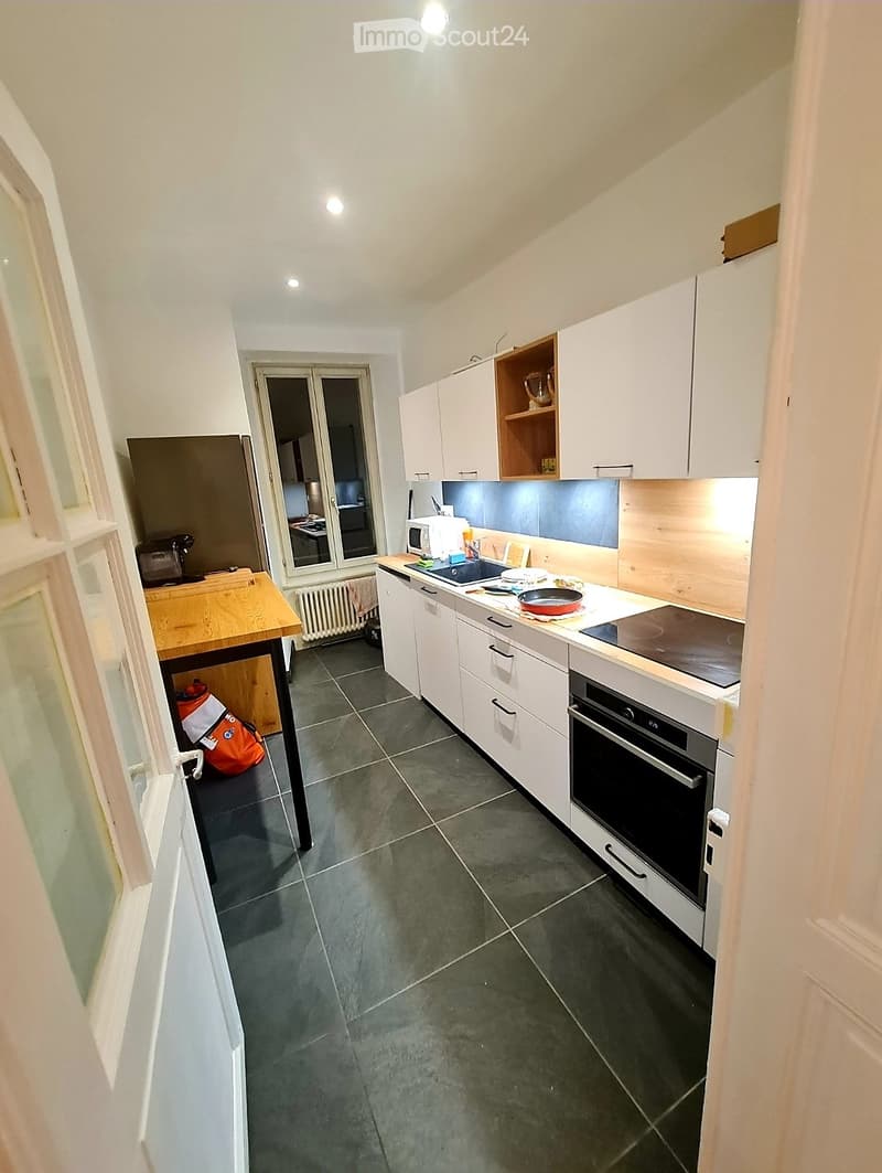 modern kitchen with white cabinets, tiled floor, wooden countertop, oven, sink, refrigerator
