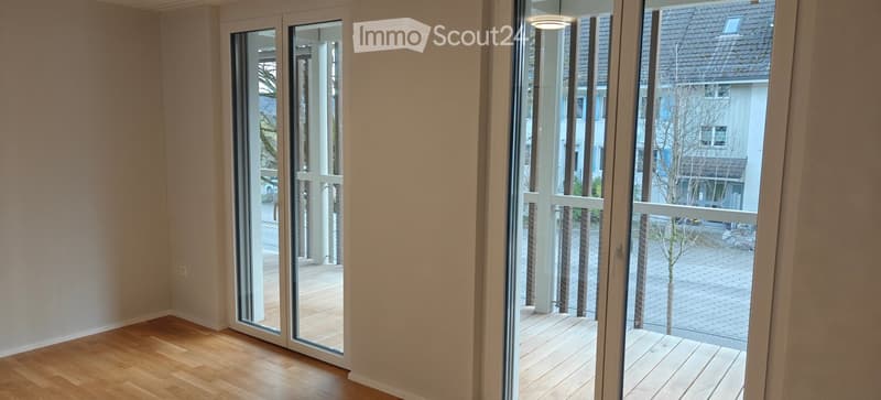 wide open sliding glass doors leading to balcony, wooden floor