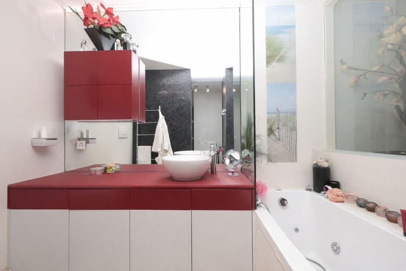 modern bathroom with red and white cabinets, white bathtub, white sink, red countertop, glass shower enclosure