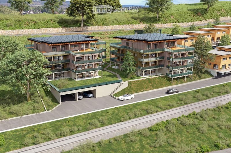 Multiple residential buildings with solar panels, green roofs, balconies, garages, and scenic views.