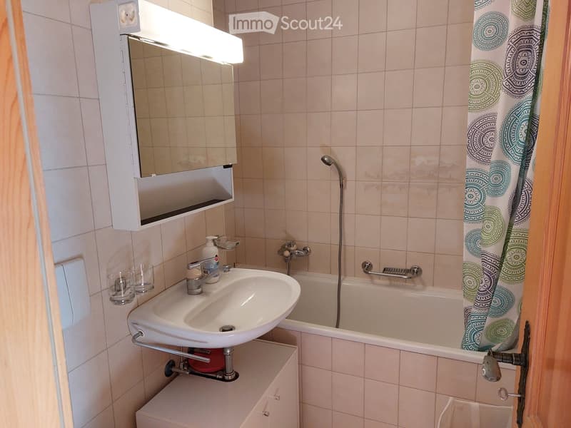 Bathroom with bathtub, sink, mirror, and shower head