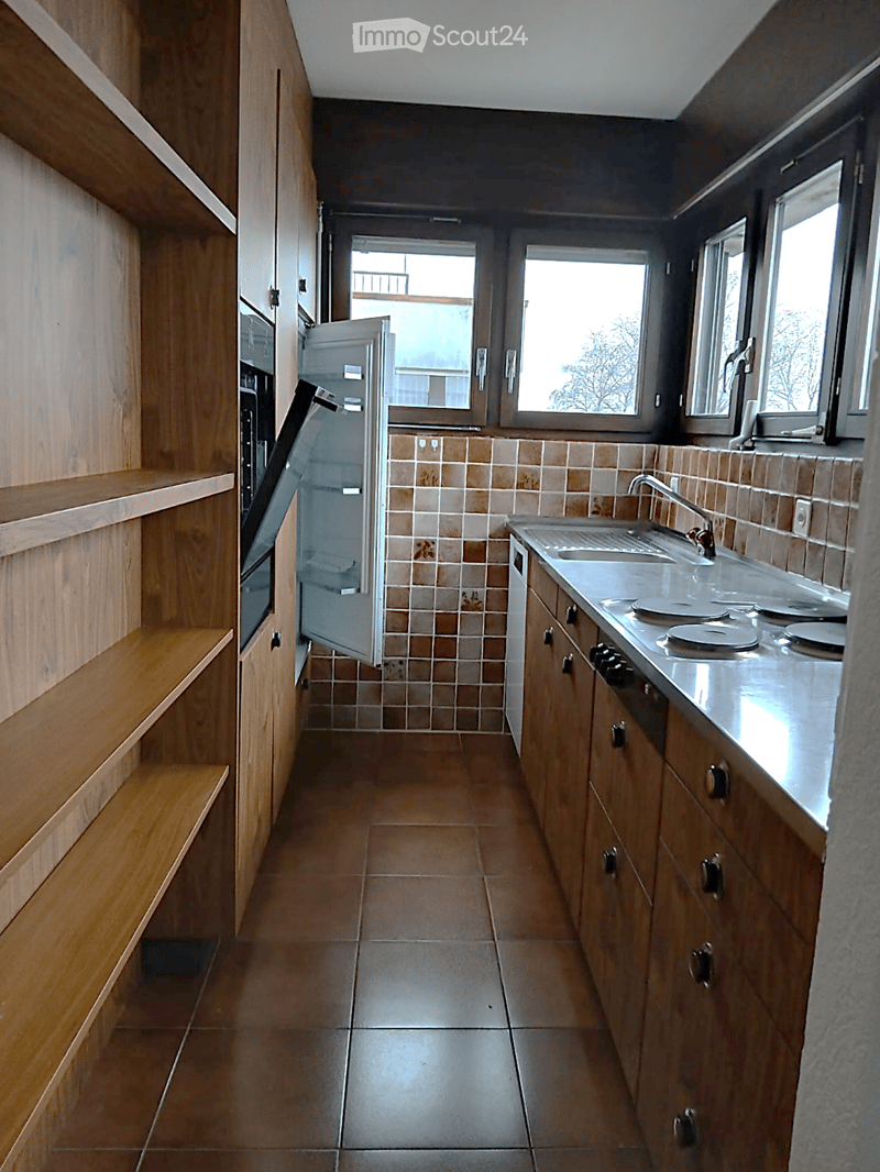 kitchen with wooden cabinets, tiled floor, open refrigerator, sink, gas stove, oven