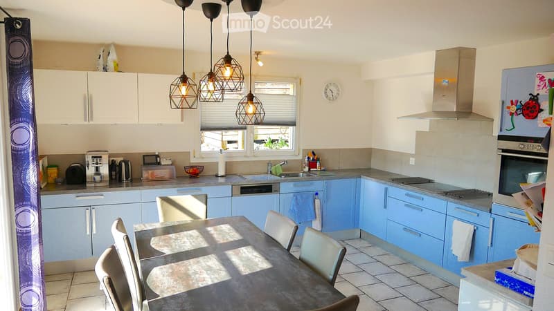 kitchen with dining area, blue cabinets, granite countertops, stainless steel appliances, pendant lights, dining table with chairs