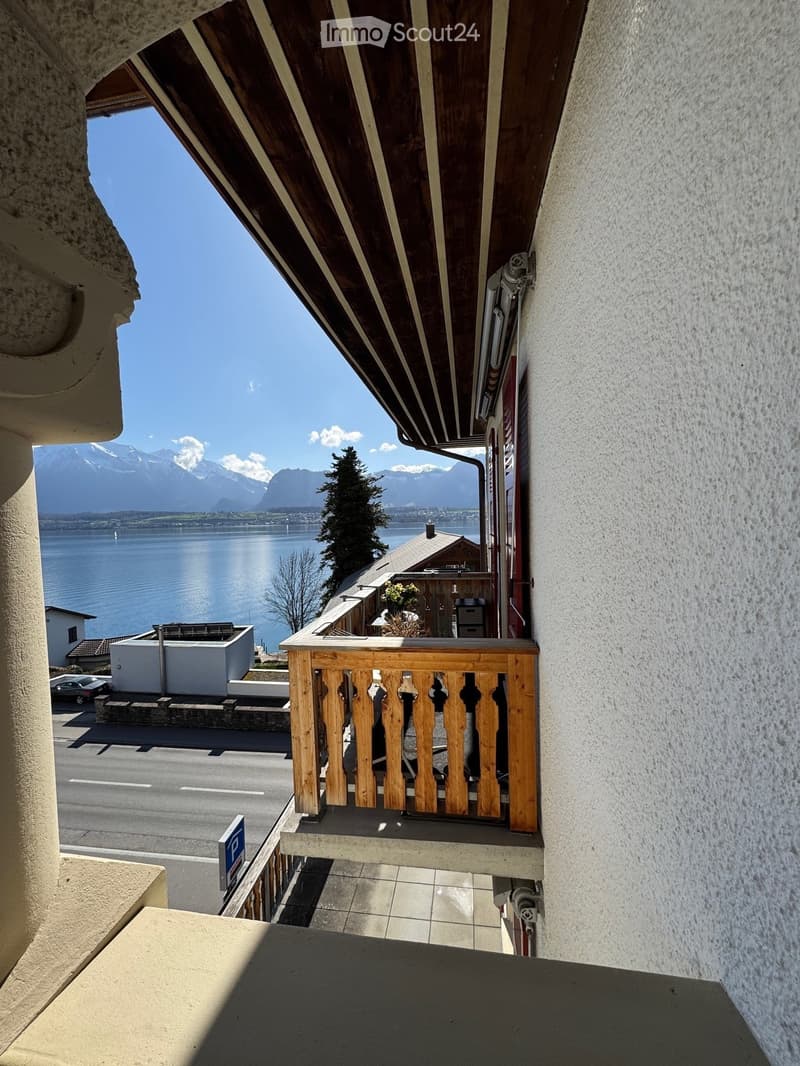 balcony with wooden railing, view of a lake and mountains