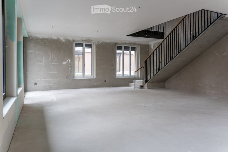 Empty room, concrete floor, concrete walls, two windows, staircase