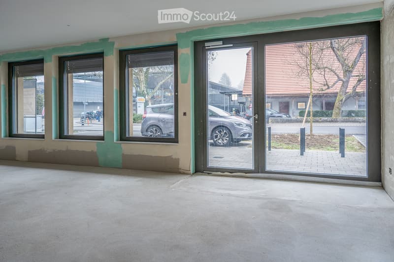 Empty room with three windows, glass door, and a concrete floor.