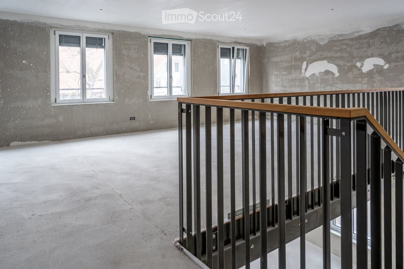 Empty room, concrete floor, three windows, metal railing