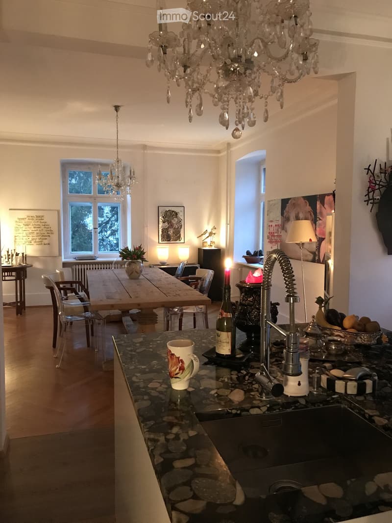 dining room with wooden table, chairs, chandelier, radiator, lamp, bowl, bottle, cup, sink, faucet, countertop