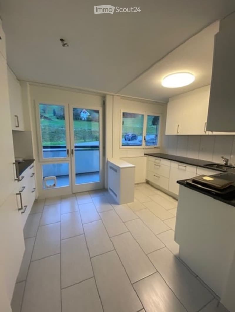 modern kitchen with white cabinets, tiled floor, large windows, balcony, view of the outside