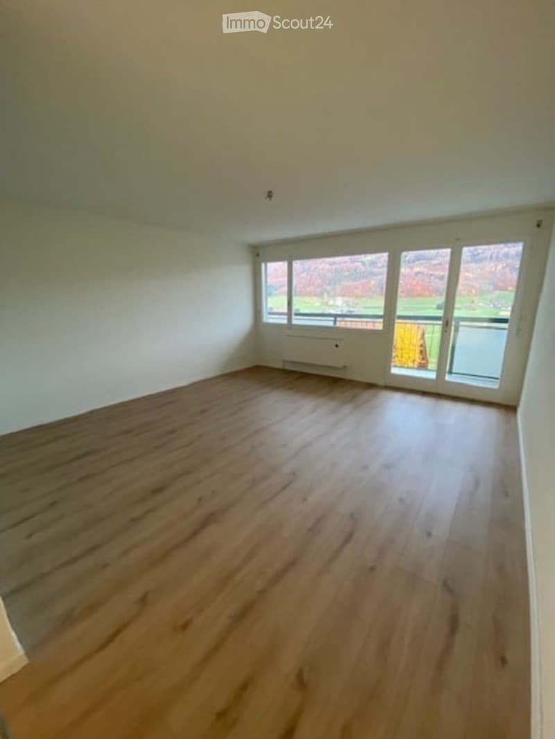 empty room, wooden floor, white walls, large windows, balcony